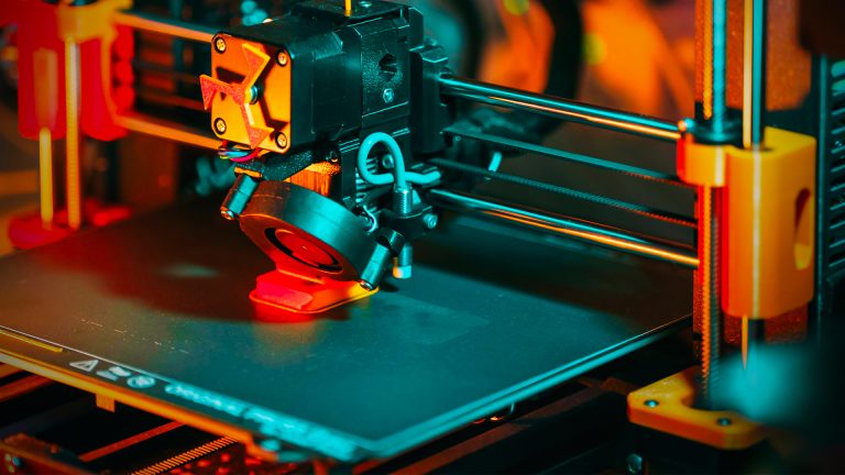 Close-up of the hotend of a 3D printer, highlighting the metal extruder and nozzle used for printing Star Wars dioramas.